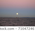 The gradation sky of the setting sun and the full moon rising from the sea 71047246