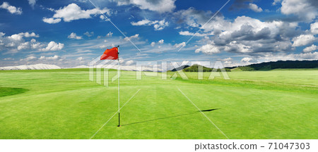 Golf field with a red flag 71047303