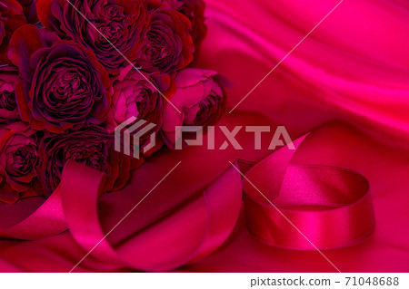 A bouquet of passionate red roses and a wedding ring 71048688