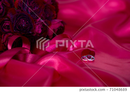 A bouquet of passionate red roses and a wedding ring A bouquet of passionate red roses and a wedding ring 71048689