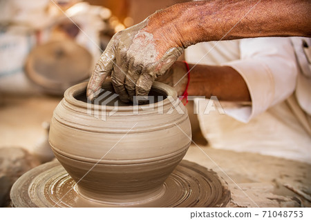 Potter at work makes ceramic dishes. Rajasthan. 71048753