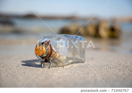Message in the bottle against the Sun setting down 71048767