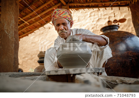 Potter at work makes ceramic dishes. Rajasthan. 71048793