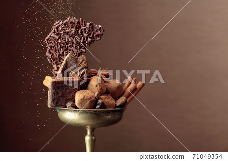 Various chocolates with ingredients in an old brass bowl. Various chocolates with ingredients in an old brass bowl. 71049354