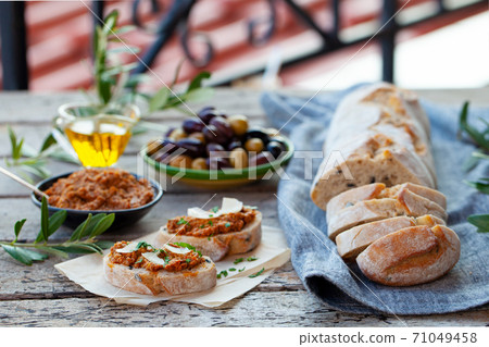 Ciabatta bread crostini, bruschetta with olive tapenade. Wooden background. Ciabatta bread crostini, bruschetta with olive tapenade. Wooden background. 71049458