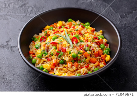 Asian fried rice with egg and vegetables. Dark stone background. Close up. 71049671