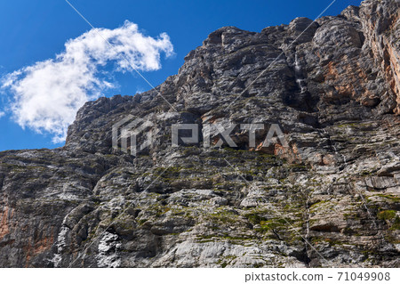 sheer rock with a waterfall against the sky sheer rock with a waterfall against the sky 71049908