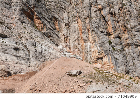 talus at the foot of a sheer cliff in a mountainous area 71049909