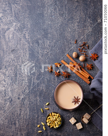 Indian masala tea with milk and spices in mug. Grey background. Copy space. Top view. 71050066