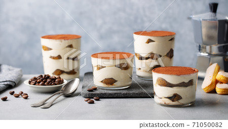 Tiramisu dessert in glass on table. Confectionery shop menu. Grey background. 71050082