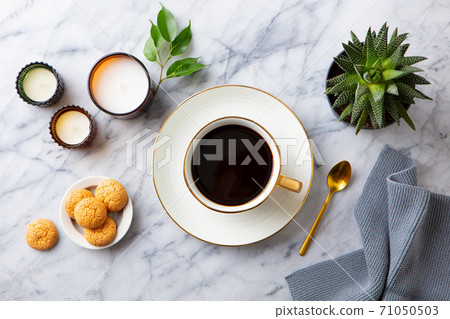 Cup of black coffee with coffee beans on marble table. Close up. Top view. 71050503