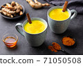 Turmeric drink, latte, tea, milk with cinnamon in a mug with fresh and powder turmeric. Grey background. Close up. 71050508