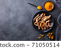 Fresh turmeric, curcuma, tumeric roots, powder and dried slices. Dark background. Copy space. Top view. 71050514