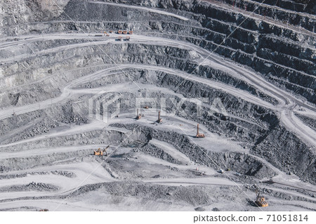 Aerial view industrial of opencast mining quarry with lots of machinery at wo Aerial view industrial of opencast mining quarry with lots of machinery at wo 71051814