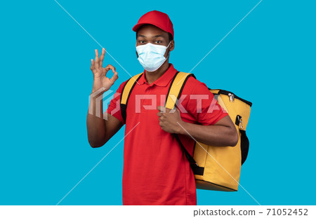 African american delivery man in medical mask wearing thermo bag African american delivery man in medical mask wearing thermo bag 71052452