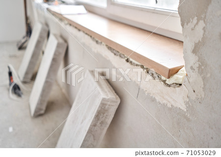 Wooden window sill, plywood covered with oak veneer. Window sill installation process. Interior design, building, home improvement, diy concept. 71053029