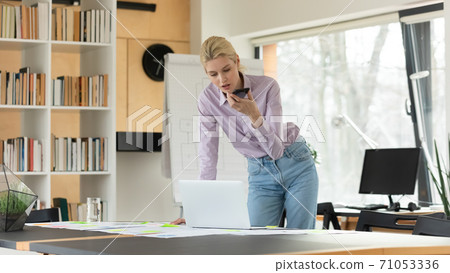Focused young businesswoman busy with office work. 71053336