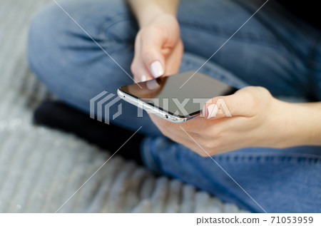 A young girl is using her mobile phone. Communication at a distance. A young girl is using her mobile phone. Communication at a distance. 71053959