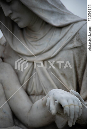 Stone cemetery statue, Mary holding Jesus's hand. Stone cemetery statue, Mary holding Jesus's hand. 71054163