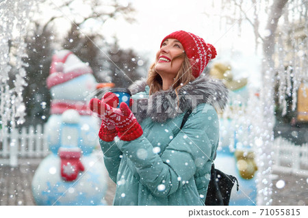 Beautiful lovely middle-aged girl with curly hair warm winter jackets stands ice rink background Town Square. Beautiful lovely middle-aged girl with curly hair warm winter jackets stands ice rink background Town Square. 71055815
