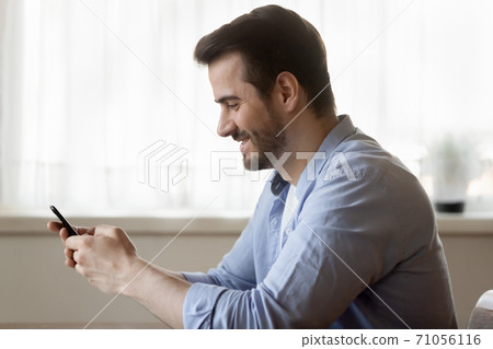 Happy smiling young man making call by smartphone Happy smiling young man making call by smartphone 71056116