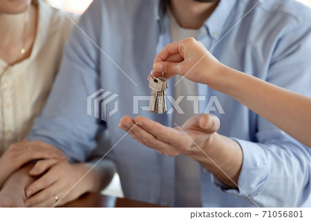Young spouses receiving keys of purchased dwelling from realestate dealer Young spouses receiving keys of purchased dwelling from realestate dealer 71056801
