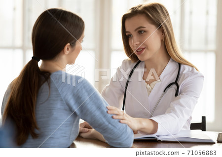 Understanding caring female doctor supporting worried anxious young woman patient 71056883
