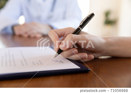 Young female hand holding pen able to sign paper contract Young female hand holding pen able to sign paper contract 71056988