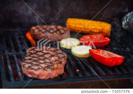 Beef steaks on the grill with flames Beef steaks on the grill with flames 71057376