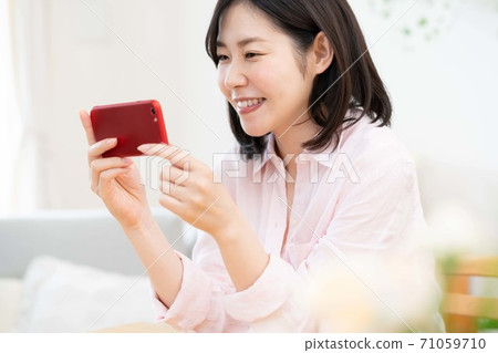 看智能手機的中部婦女 看智能手機的中部婦女 71059710