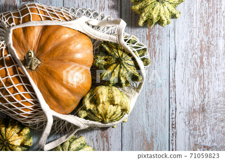 Thanksgiving background, composition with autumn pumpkins in shopping eco-friendly bag on wooden background. 71059823