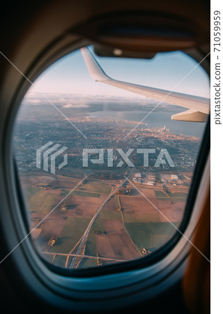 Airplane interior with window view of the Baltic sea and clouds. 71059959
