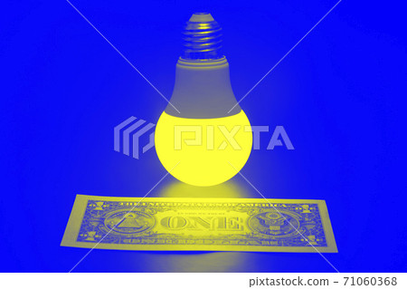 Glowing LED lamp and one dollar bill on a blue background. Business and savings. Modern technology and electricity 71060368