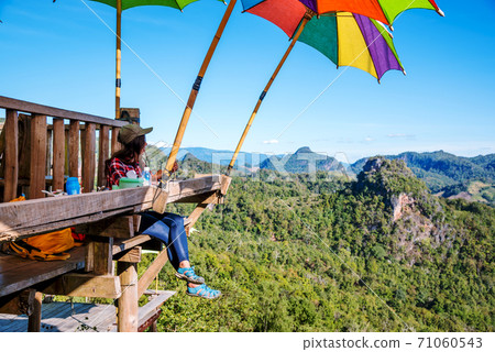The girl sitting eating noodle in the rural village hanging legs style for viewpoint on the mountain,The local attractions of Mae Hong Son province Thailand. 71060543