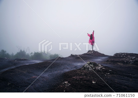 tourist with pink rain coat Stand View the scenery natural beautiful touch fog at Phu Hin Rong Kla National Park. travel nature, Travel relax, Travel Thailand, rainy season. 71061150