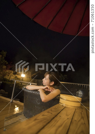年輕女子在晚上洗個私人露天浴池 年輕女子在晚上洗個私人露天浴池 71061350