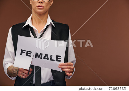 Midsection of manlike woman in elegant suit cutting syllable fe from word female Midsection of manlike woman in elegant suit cutting syllable fe from word female 71062585
