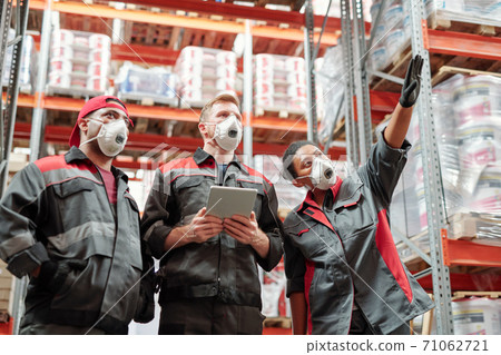 Young intercultural warehouse workers discussing new assortment at meeting 71062721