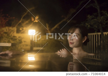 Young woman taking a private open-air bath at night Hot spring image GoTo Travel Campaign 71064014