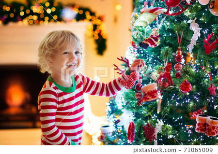 Child decorating Christmas tree. Kid on Xmas eve. Child decorating Christmas tree. Kid on Xmas eve. 71065009