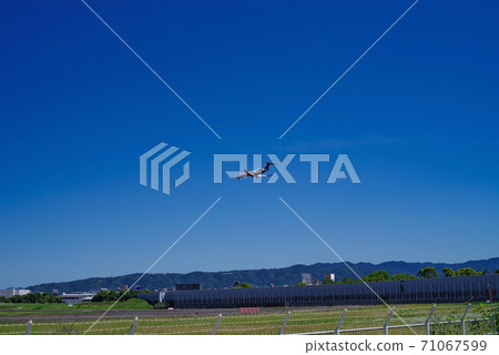 Scenery with Itami Airport where the blue sky spreads and a small passenger plane landing 71067599
