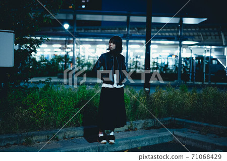 A woman wandering around the city at night A woman wandering around the city at night 71068429