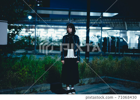 A woman wandering around the city at night 71068430