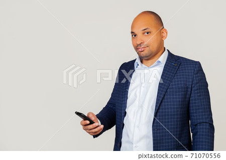 Portrait young african american businessman guy, uses smartphone with confident expression on smart Portrait young african american businessman guy, uses smartphone with confident expression on smart 71070556