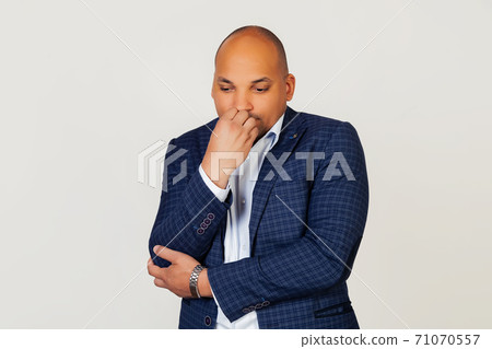 Portrait of an upset young African American businessman guy, looks tense and nervous with hands on 71070557