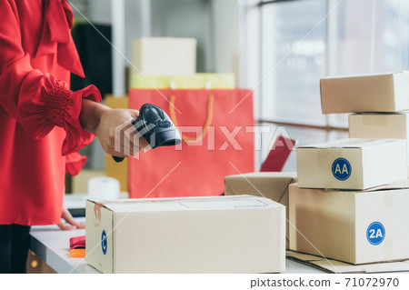Online seller works at home office and packs shipping delivery box to customer. Online seller works at home office and packs shipping delivery box to customer. 71072970