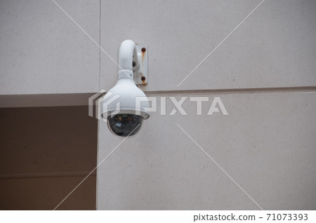 Security CCTV dome camera attached to a white wall near the door Security CCTV dome camera attached to a white wall near the door 71073393