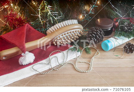 Massage brush and Christmas decorations on wooden background. 71076105