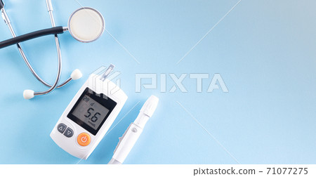 Top view of diabetes tester set with stethoscope on bright blue pastel background. Healthy care and medical concept. 71077275