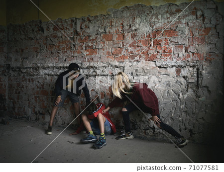 Teenage boy attacked by thugs in abandoned building, gang violence and bullying concept. Teenage boy attacked by thugs in abandoned building, gang violence and bullying concept. 71077581